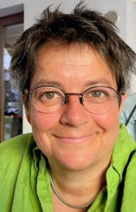 Auf dem Bild schaut Astrid Rickenbacher in die Kamera und lächelt.